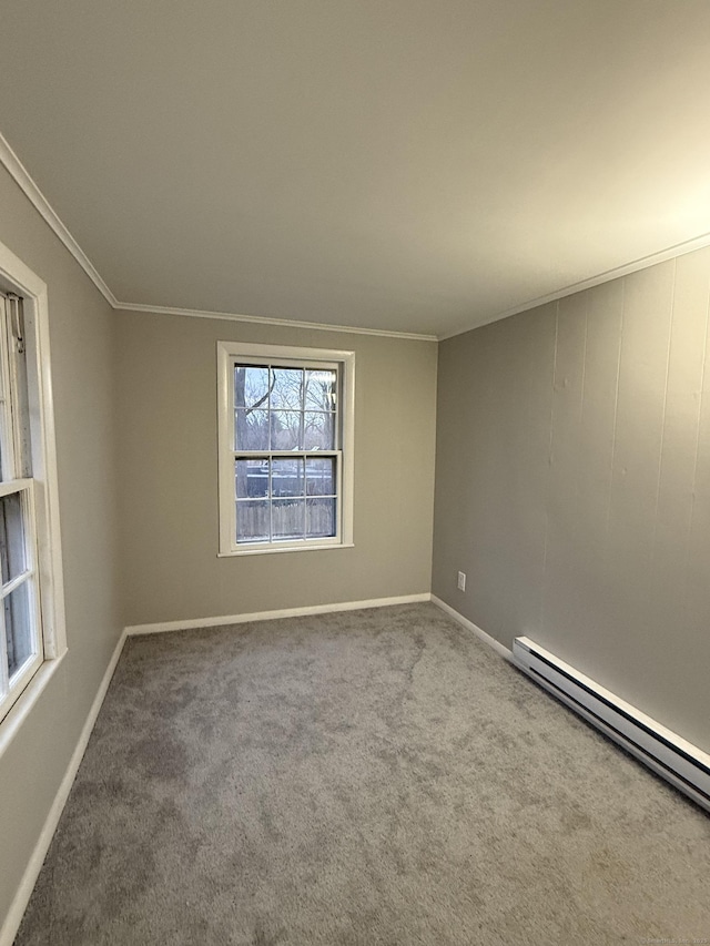 carpeted spare room featuring a baseboard radiator, crown molding, and baseboards