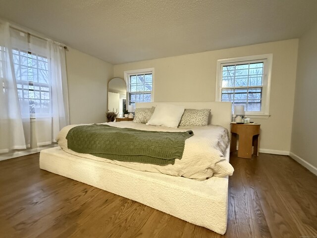 bedroom featuring baseboards and dark wood-style floors