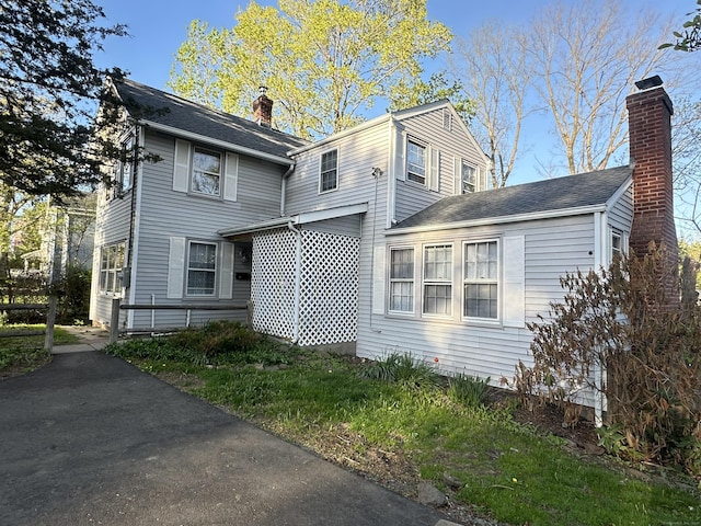 view of front of house with roof with shingles and a chimney