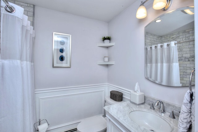 full bathroom with toilet, curtained shower, vanity, and wainscoting