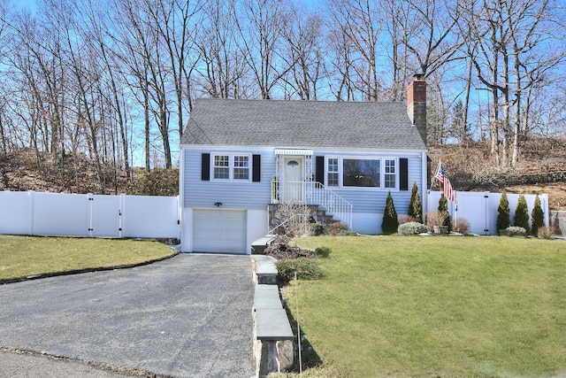 view of front facade with aphalt driveway, a front yard, fence, and a gate