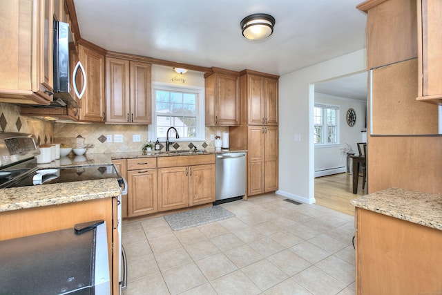 kitchen with stainless steel appliances, a baseboard heating unit, a sink, and light stone countertops