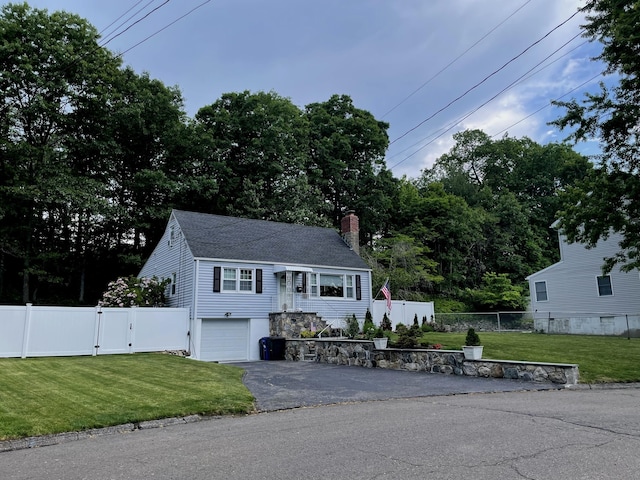 bi-level home featuring driveway, a fenced front yard, a front yard, and a gate