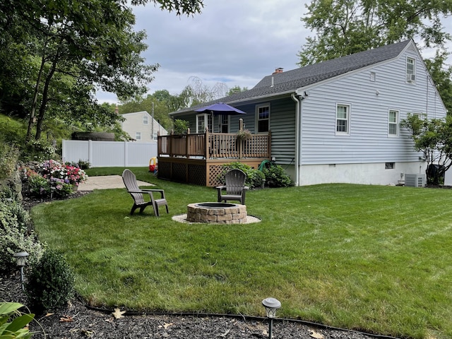 view of yard with a fire pit, a deck, cooling unit, and fence