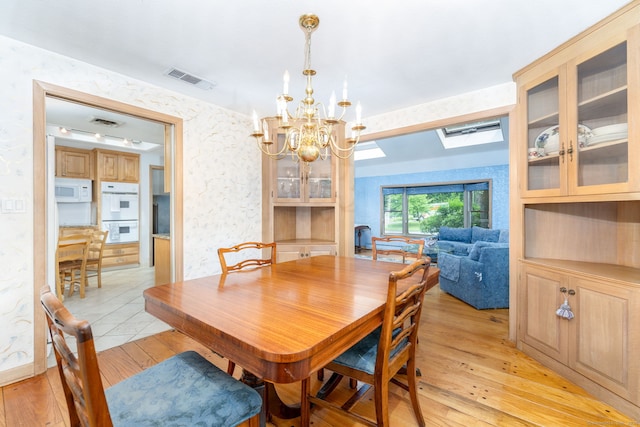 30 Holly Cir, Windsor, CT 06095 - dining area featuring a chandelier, light wood finished floors, a skylight, and wallpapered walls