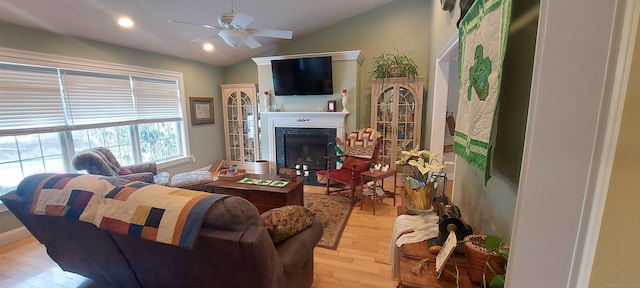 living area with ceiling fan, wood finished floors, vaulted ceiling, a fireplace, and recessed lighting