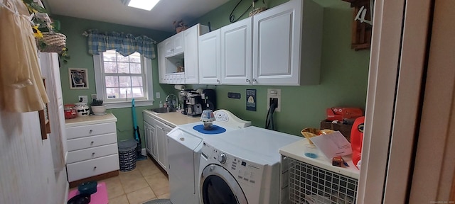 laundry area with light tile patterned floors, cabinet space, a sink, and washing machine and clothes dryer