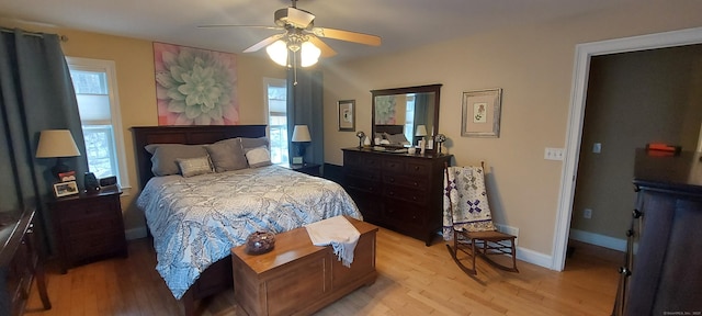 bedroom with light wood-style floors, multiple windows, and baseboards