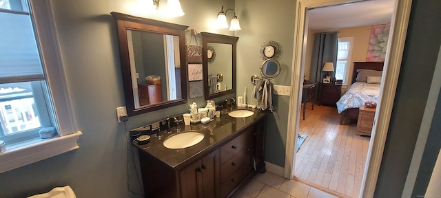 full bathroom with double vanity, ensuite bath, and a sink