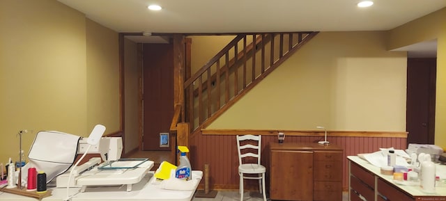 bathroom with recessed lighting, wainscoting, and wood walls