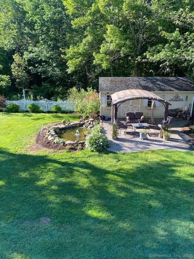 view of yard with a patio area, fence, and an outdoor structure