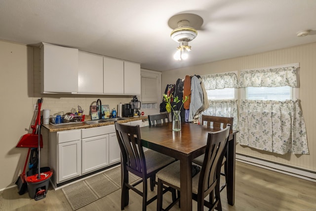 dining area featuring light wood-type flooring and baseboard heating