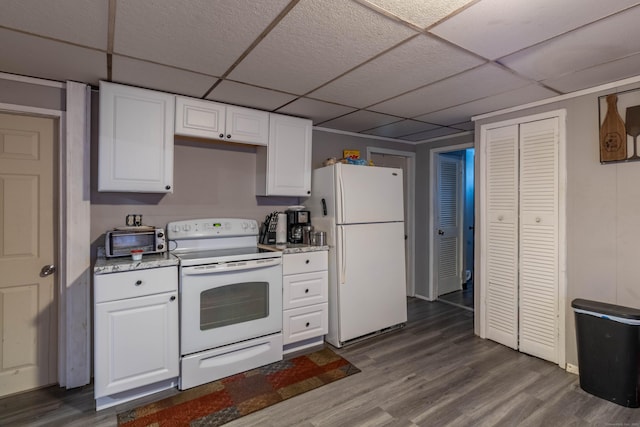 kitchen featuring white appliances, a drop ceiling, white cabinets, and dark wood-style flooring