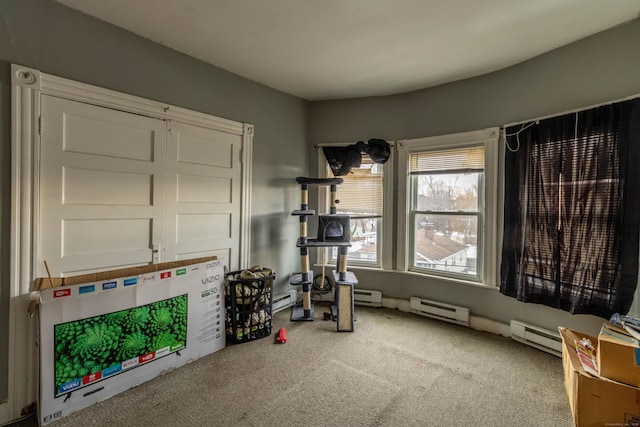 interior space with a baseboard heating unit and carpet