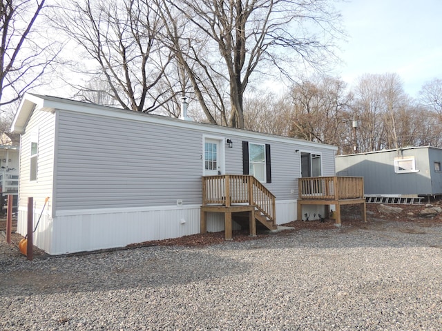 manufactured / mobile home with driveway and a wooden deck