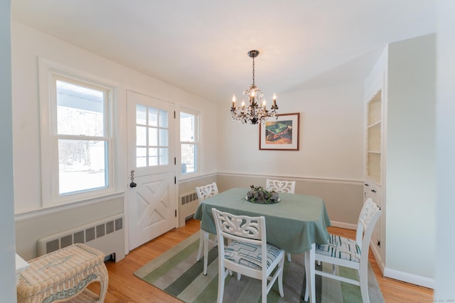 dining area featuring light wood-type flooring, baseboards, and radiator heating unit