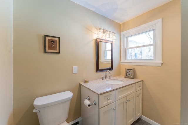 half bathroom featuring baseboard heating, vanity, toilet, and baseboards