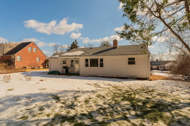 back of house featuring a chimney