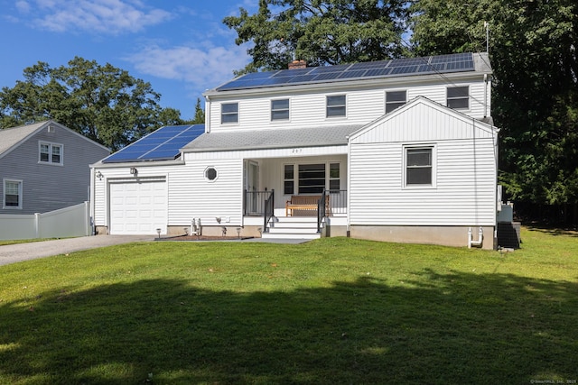 view of front of house with driveway, solar panels, an attached garage, covered porch, and a front yard