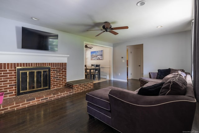 living room featuring a brick fireplace, dark wood finished floors, and recessed lighting