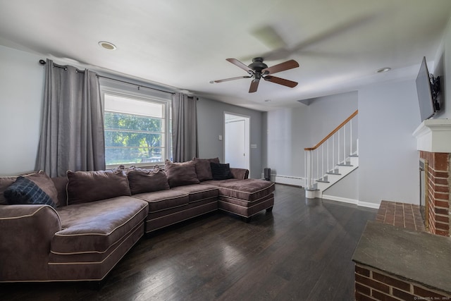 living room featuring a baseboard radiator, a fireplace, wood finished floors, baseboards, and stairs