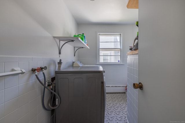 clothes washing area featuring laundry area, tile walls, wainscoting, tile patterned floors, and washer / dryer