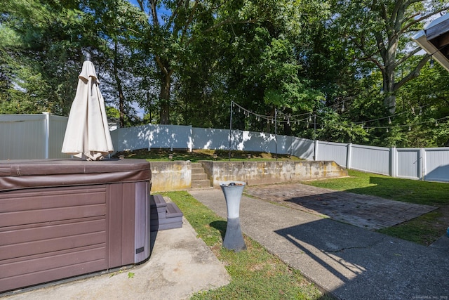 view of yard featuring a fenced backyard, a patio, and a hot tub