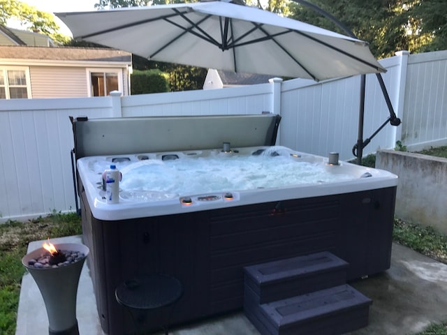 view of patio / terrace featuring fence and a hot tub