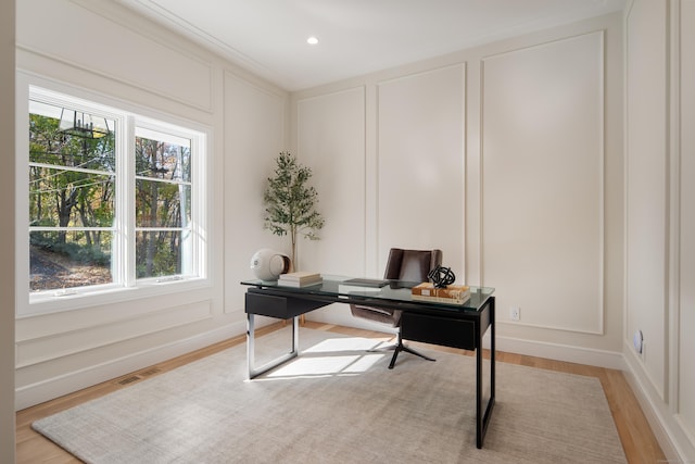 office area featuring light wood-style floors, recessed lighting, visible vents, and a decorative wall