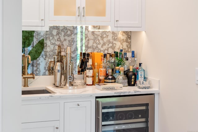 bar with a dry bar, wine cooler, decorative backsplash, and a sink