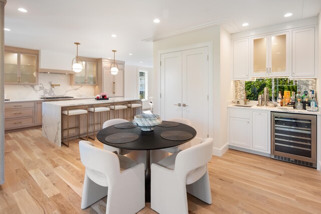 dining space with light wood-style floors, wine cooler, and recessed lighting