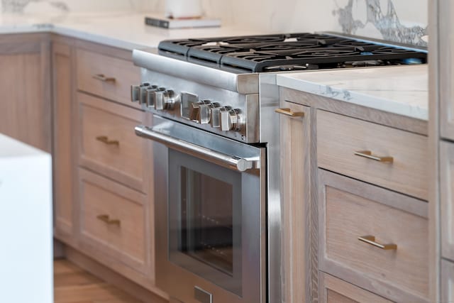 kitchen featuring light stone counters and stainless steel stove