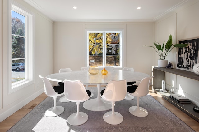 dining area featuring ornamental molding, wood finished floors, visible vents, and a healthy amount of sunlight