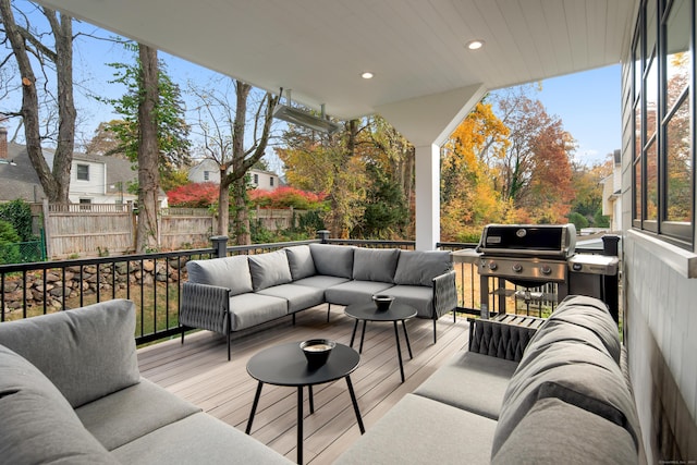 wooden terrace with a grill, fence, and outdoor lounge area