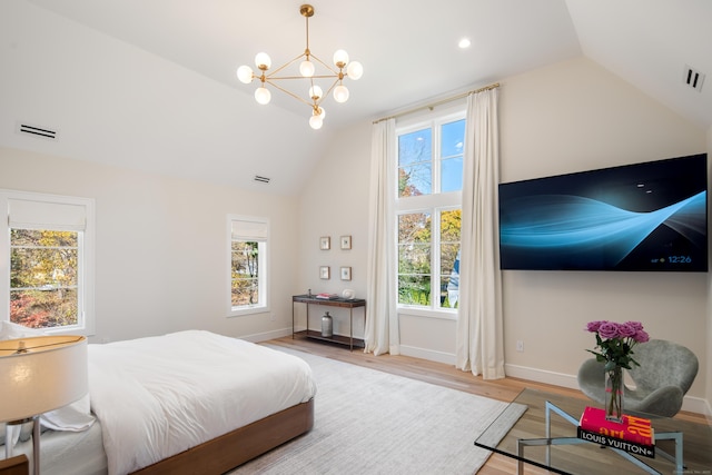 bedroom with lofted ceiling, wood finished floors, visible vents, and baseboards