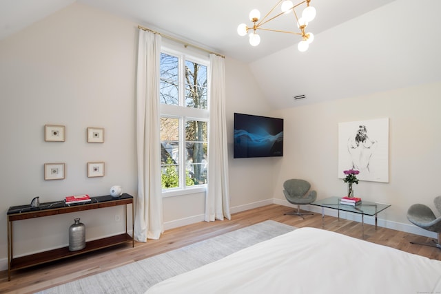 bedroom with multiple windows, vaulted ceiling, and wood finished floors