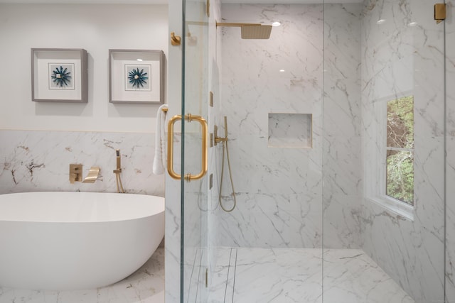 full bath with marble finish floor, a freestanding bath, and a marble finish shower