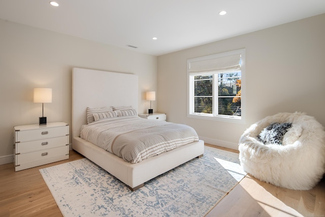 bedroom featuring light wood finished floors, baseboards, visible vents, and recessed lighting