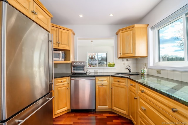 kitchen with recessed lighting, dark wood-style flooring, a sink, appliances with stainless steel finishes, and tasteful backsplash