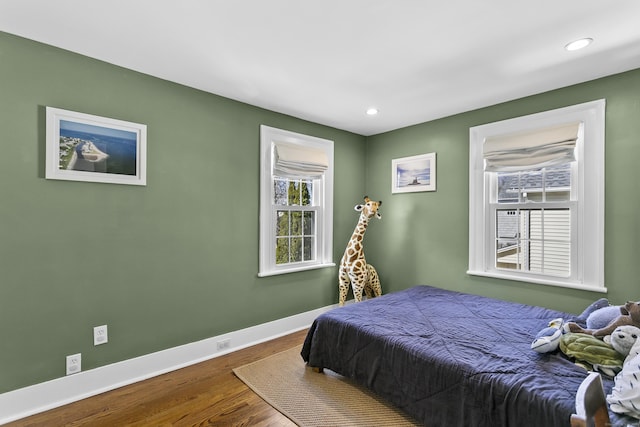 bedroom with recessed lighting, wood finished floors, and baseboards