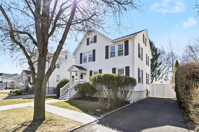 colonial-style house featuring a residential view and a front lawn