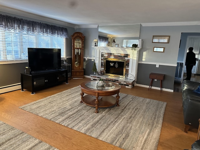 living area featuring a brick fireplace, crown molding, baseboards, and wood finished floors