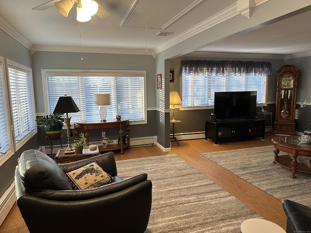 living room featuring visible vents, baseboard heating, attic access, ornamental molding, and wood finished floors