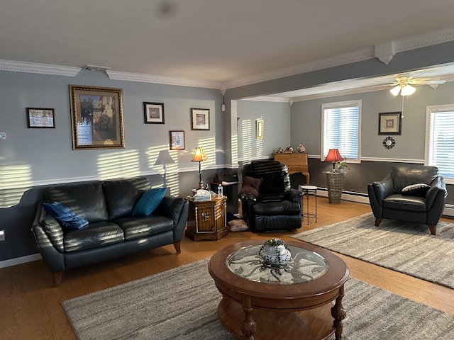 living area featuring visible vents, ceiling fan, wood finished floors, crown molding, and a baseboard heating unit