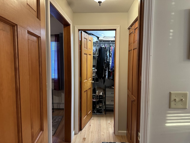 hallway featuring light wood-style floors and a baseboard heating unit