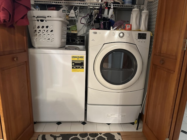 laundry room featuring laundry area, light tile patterned flooring, and washing machine and dryer