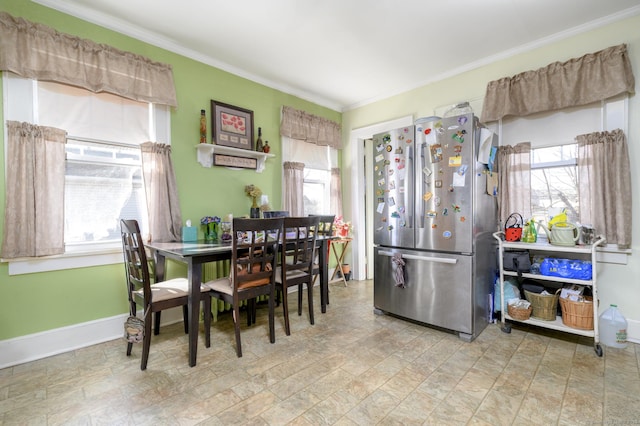 dining space with baseboards, crown molding, and a healthy amount of sunlight