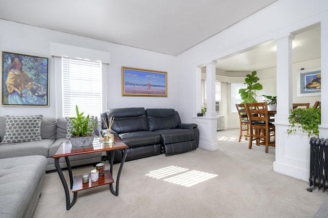 carpeted living area featuring radiator and ornate columns