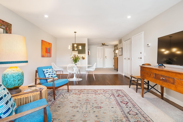 sitting room featuring ceiling fan with notable chandelier, recessed lighting, baseboards, and wood finished floors