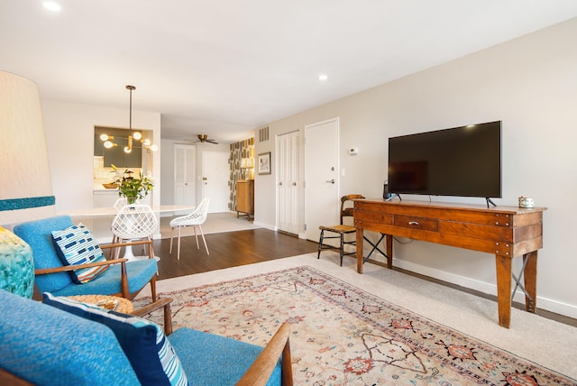 living room with visible vents, ceiling fan, baseboards, and wood finished floors